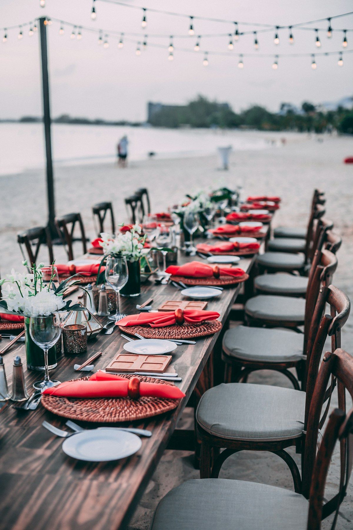 Private beachfront dinner table set under string lights in Punta Cana