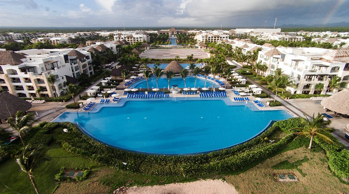 Aerial drone view of the expansive outdoor swimming pools, resort buildings, and lush tropical grounds at the Hard Rock Hotel and Casino Punta Cana.