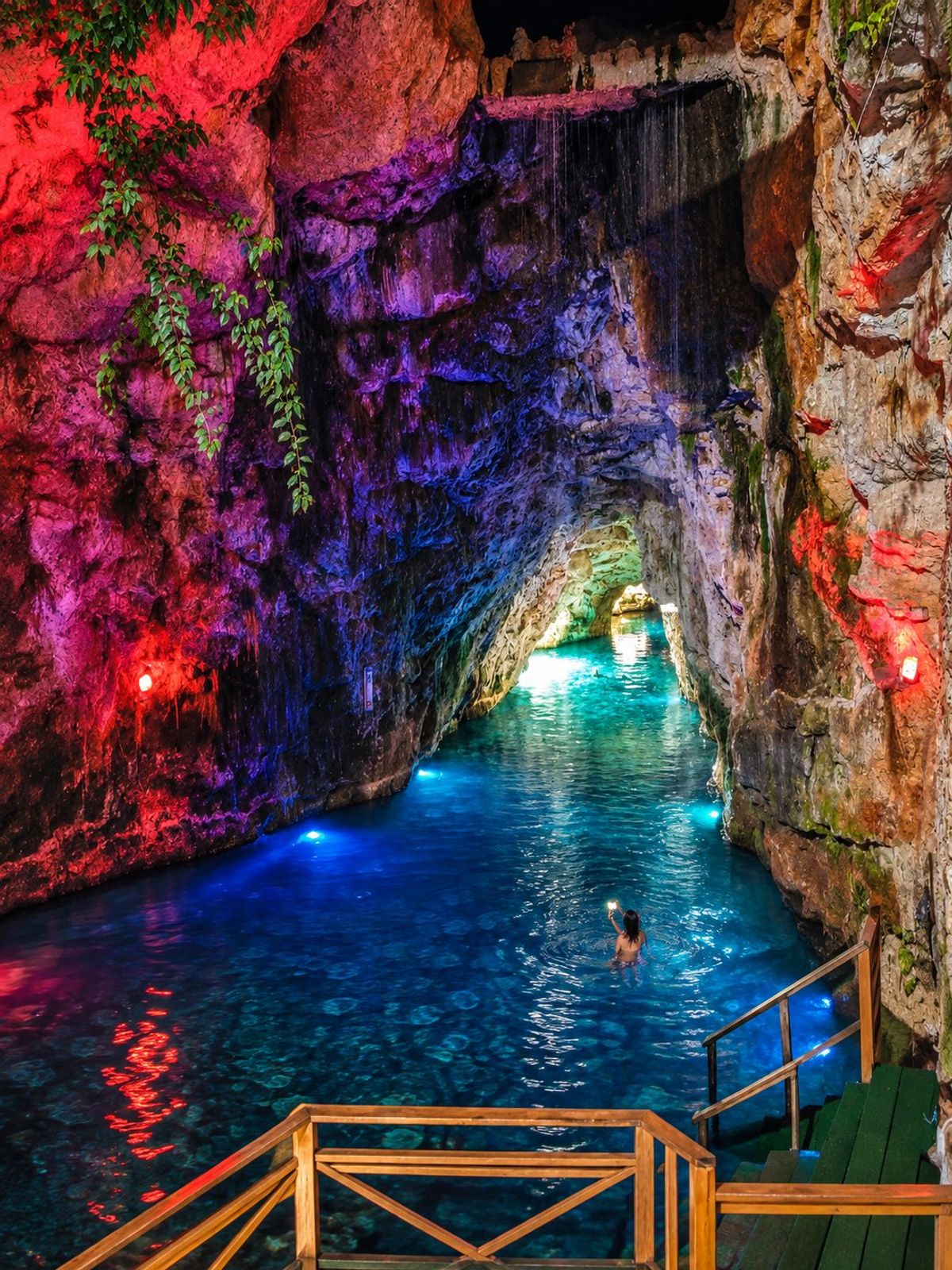 Poza de cueva subterránea iluminada en color durante una expedición de equipo