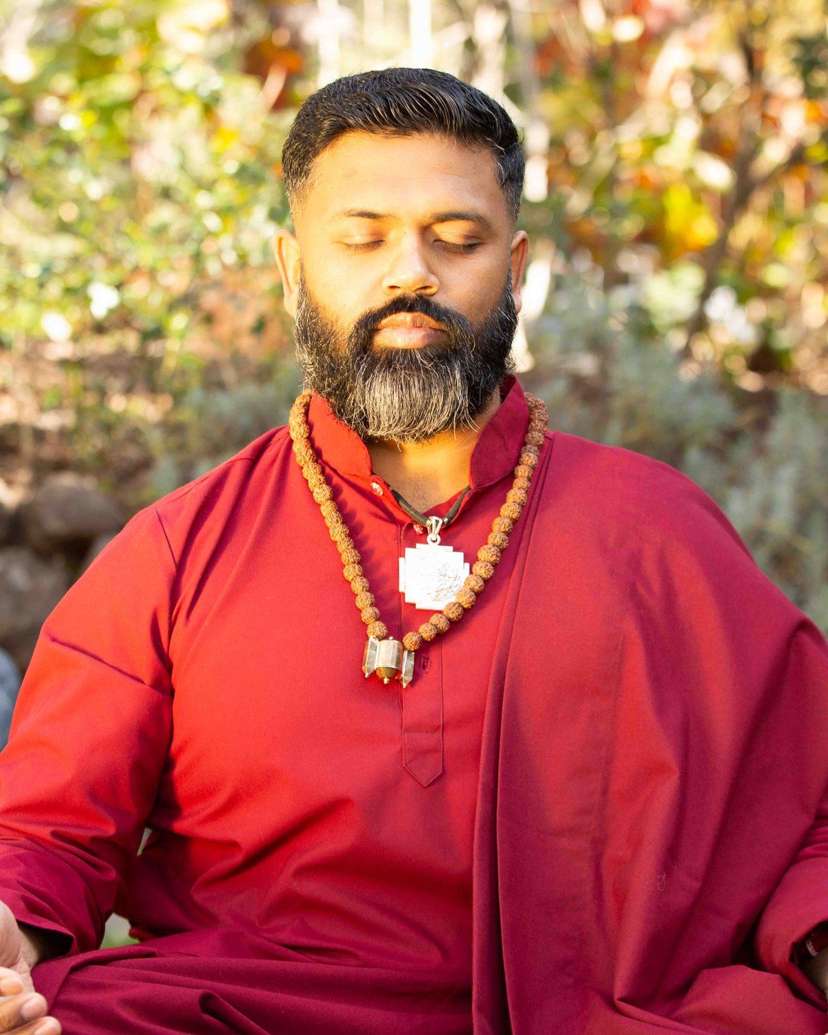 Ishan Shivanand seated in meditation in a garden