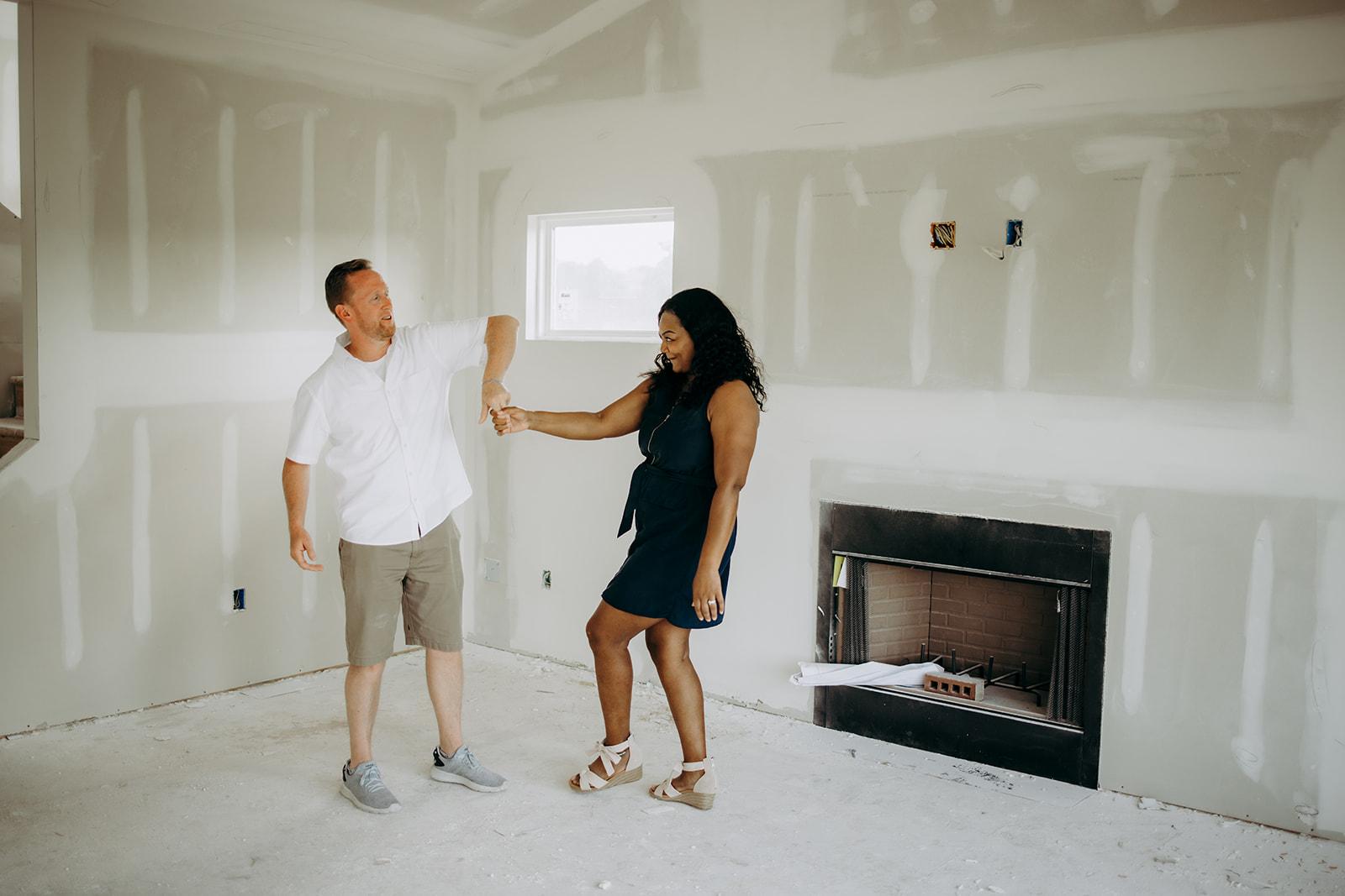 Couple standing in an under constructing living room with fireplace from Gentry Homes