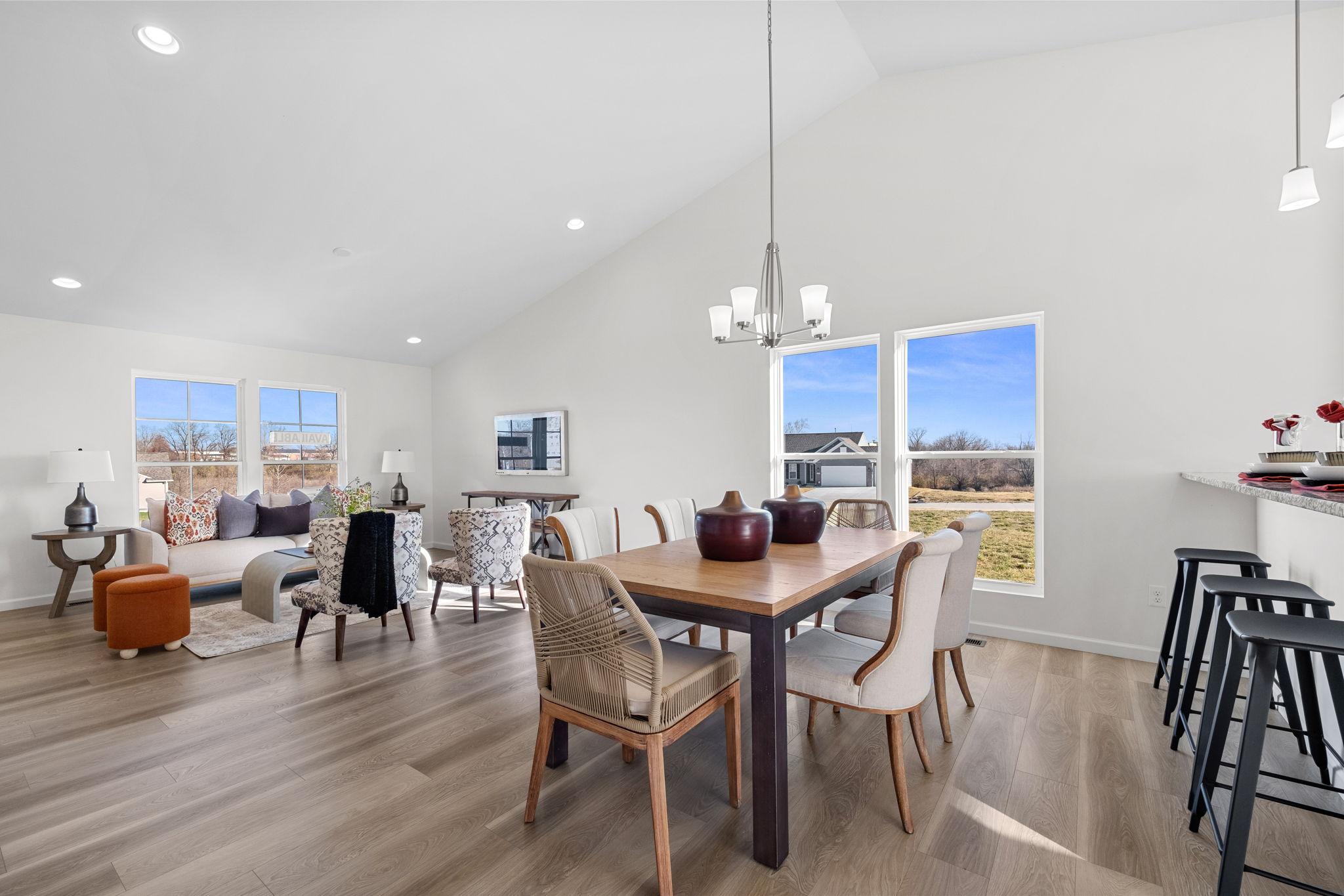 A open concept kitchen and living room space featuring cathedral ceilings.
