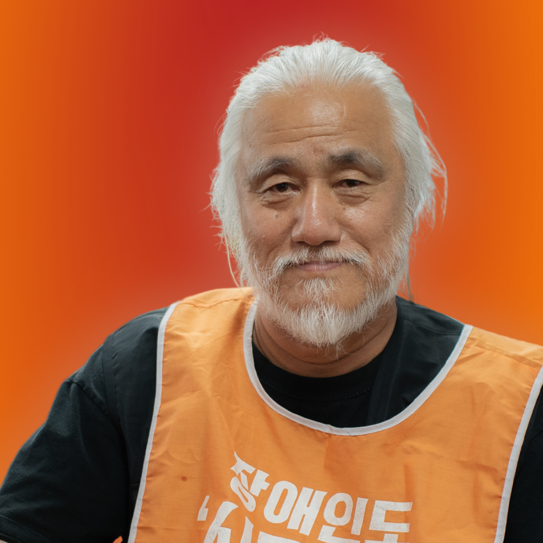 Kyung Seok Park sitting against a red and orange background