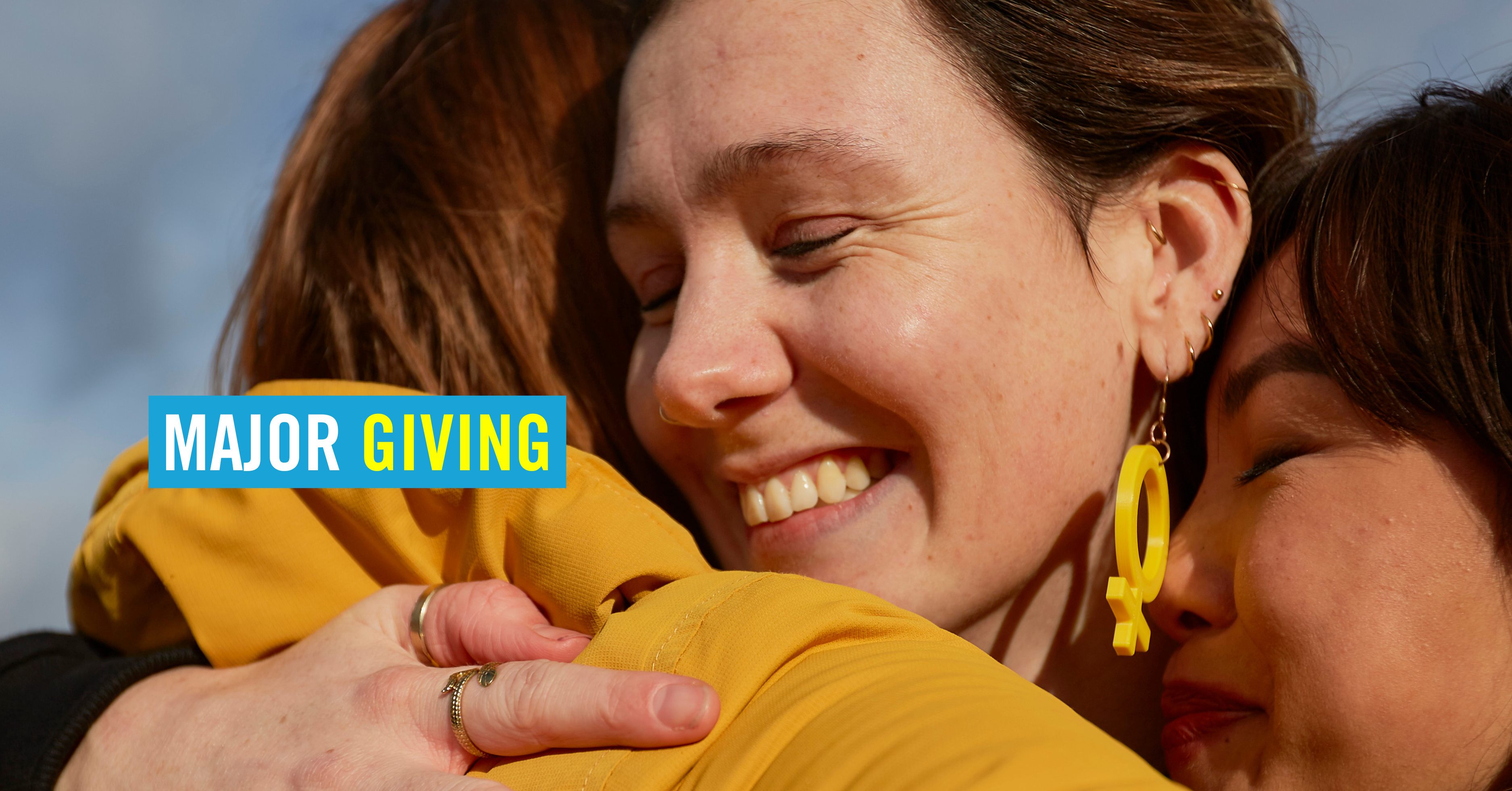 three people hugging and smiling