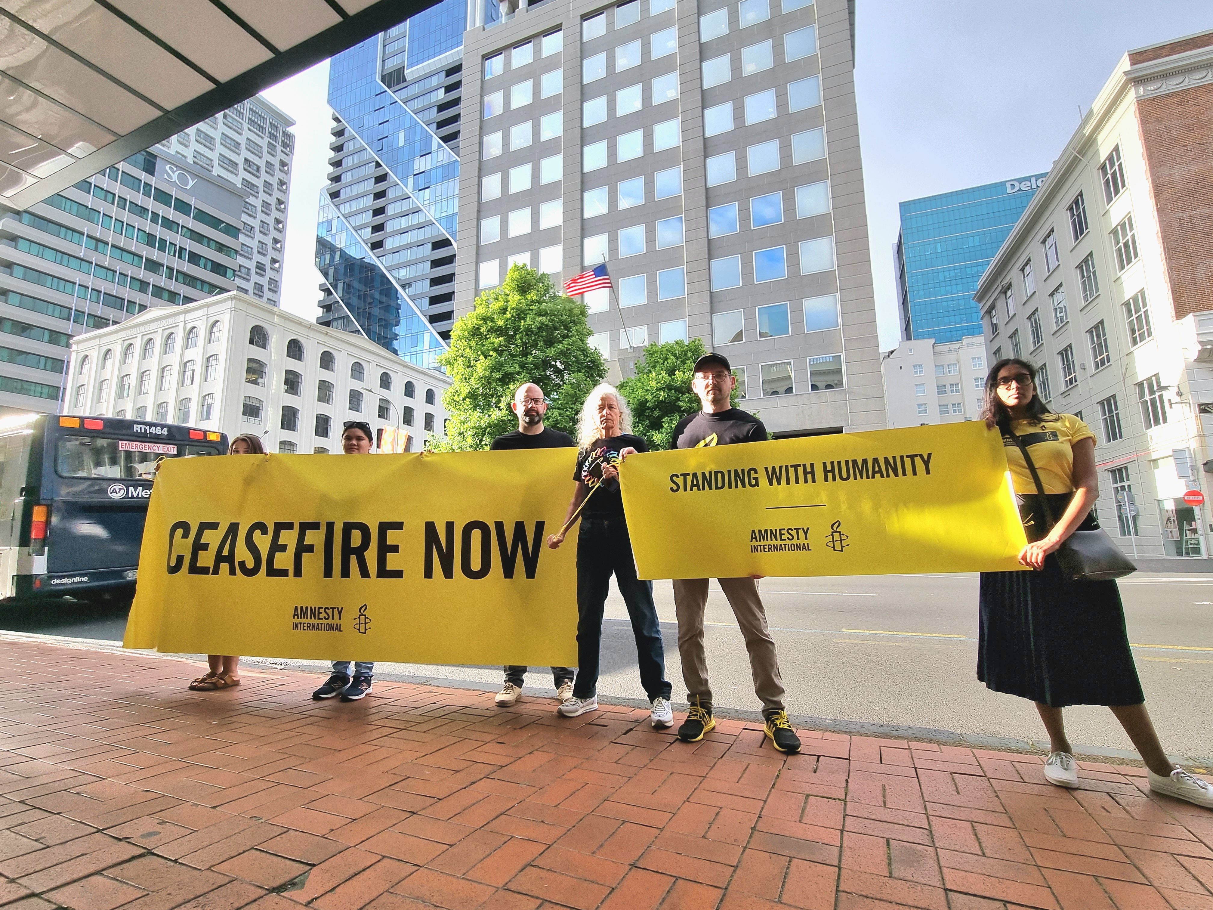 Amnesty supporters hold signs calling for a ceasefire in Gaza
