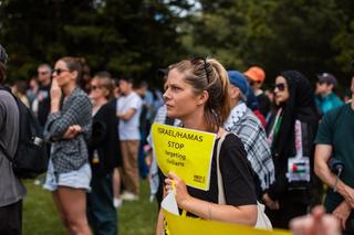 A person holds a sign calling for Israel and Hamas to stop targeting civilians