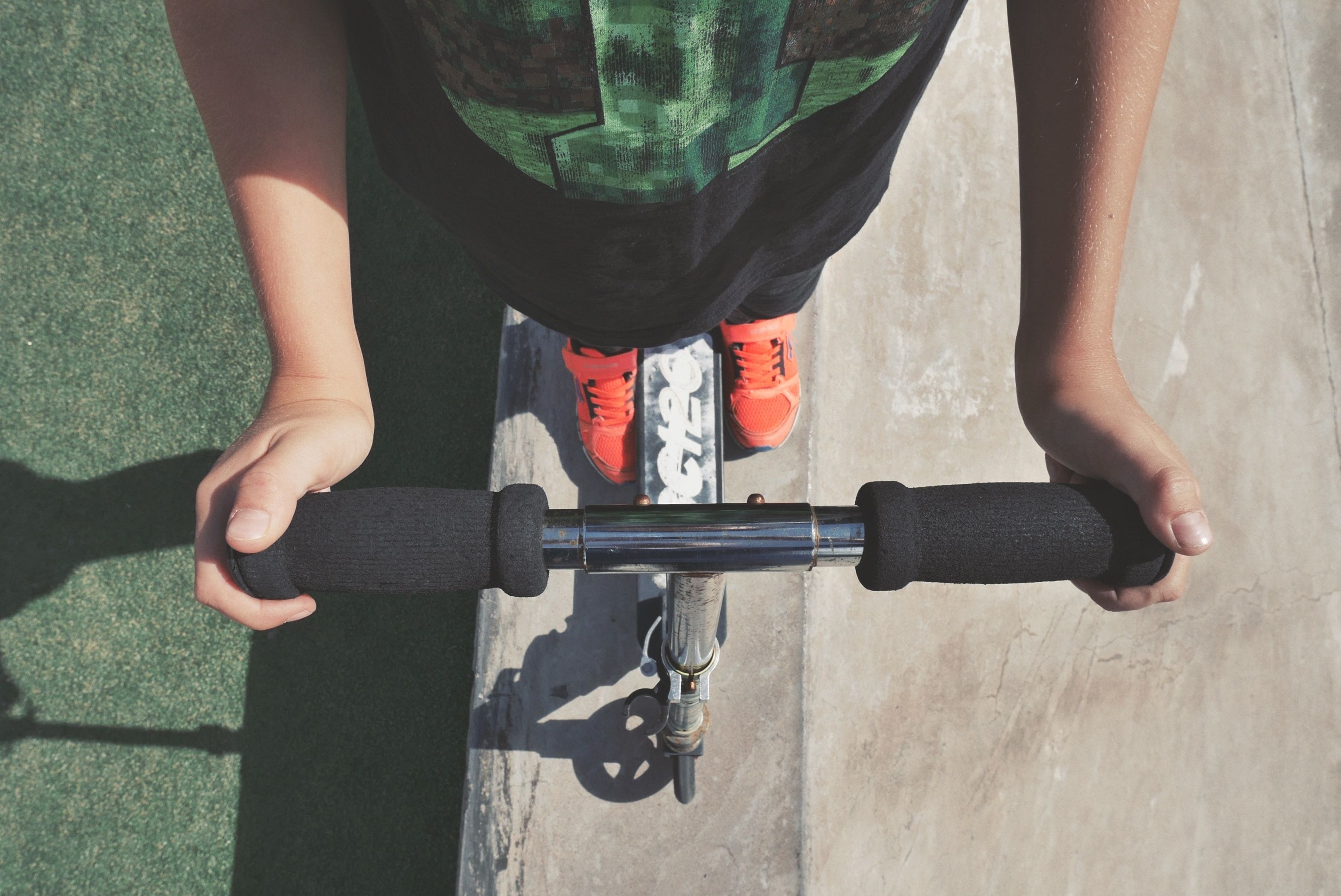 a young person stands on a scooter