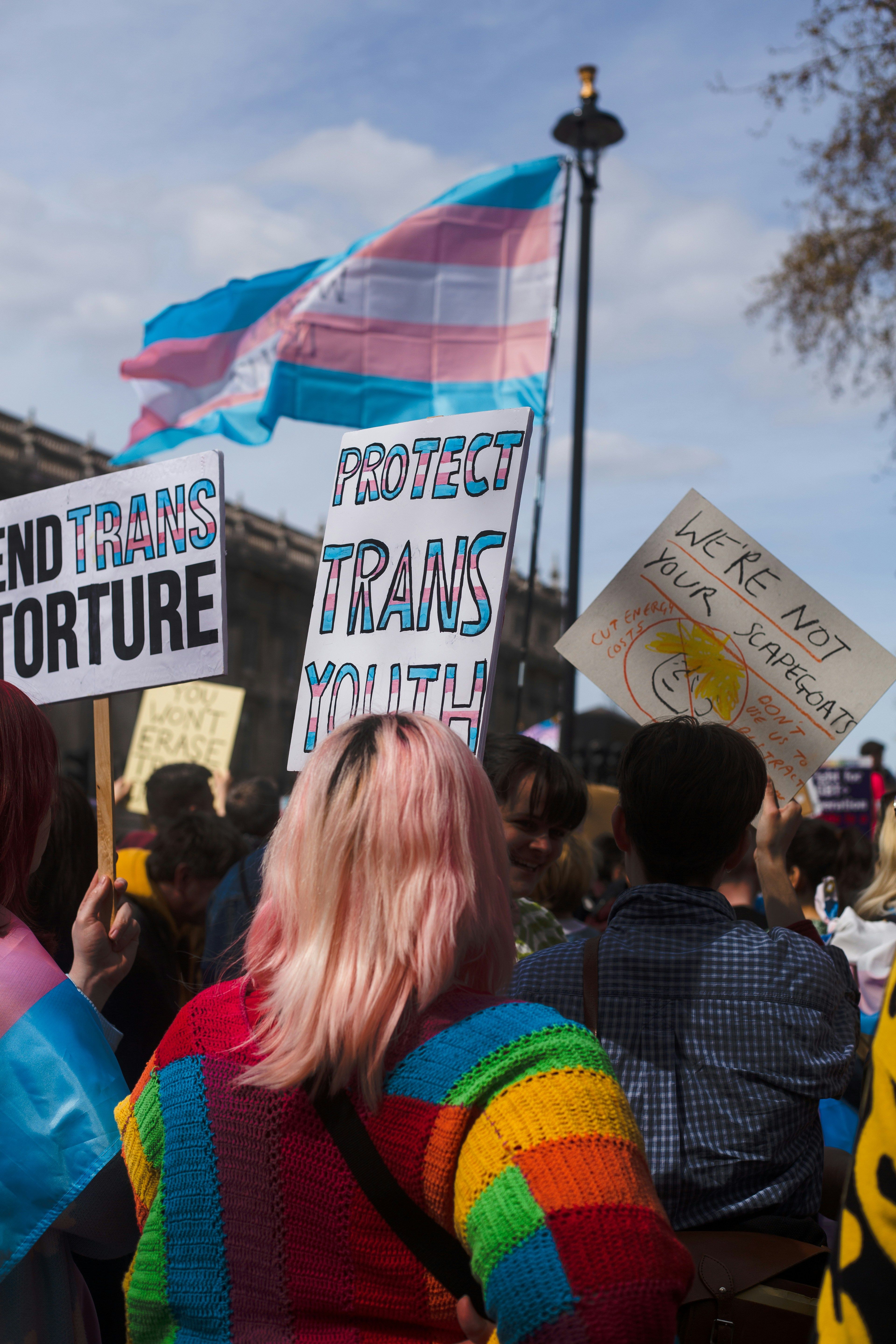 people hold pro-trans signs