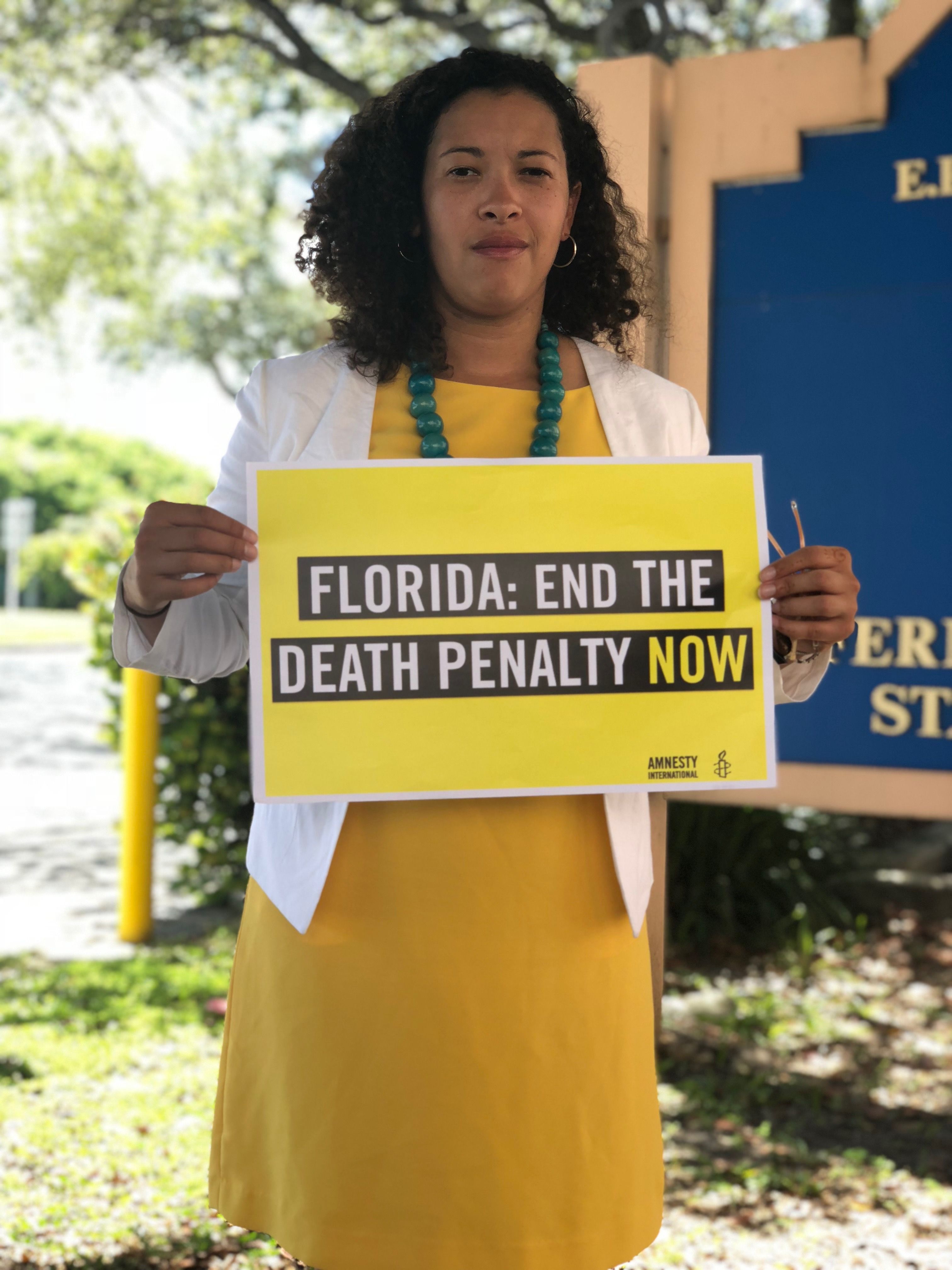 a woman holds a sign calling for the end of the death penalty in Florida