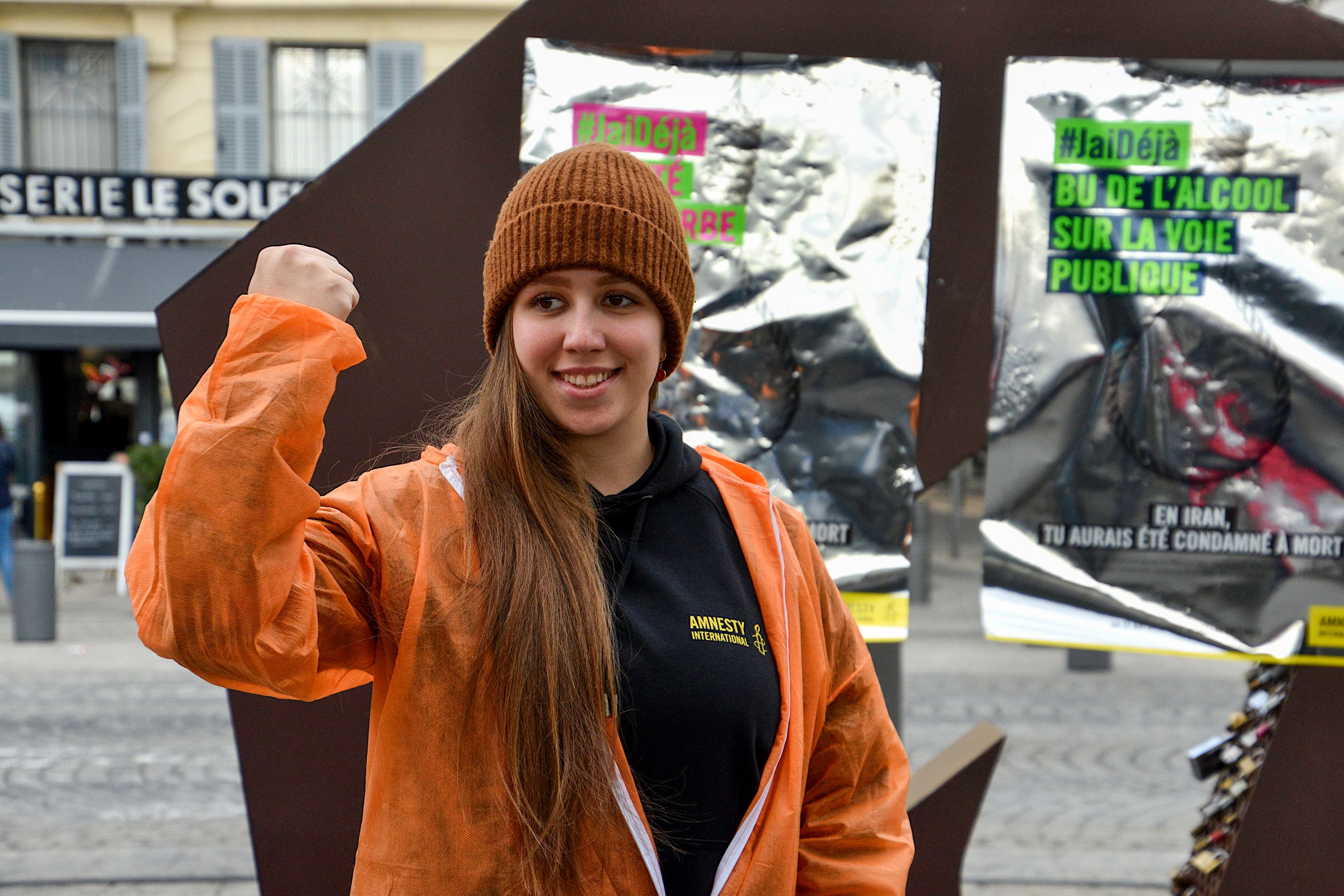 An Amnesty International activist poses in front of posters against the death penalty.
