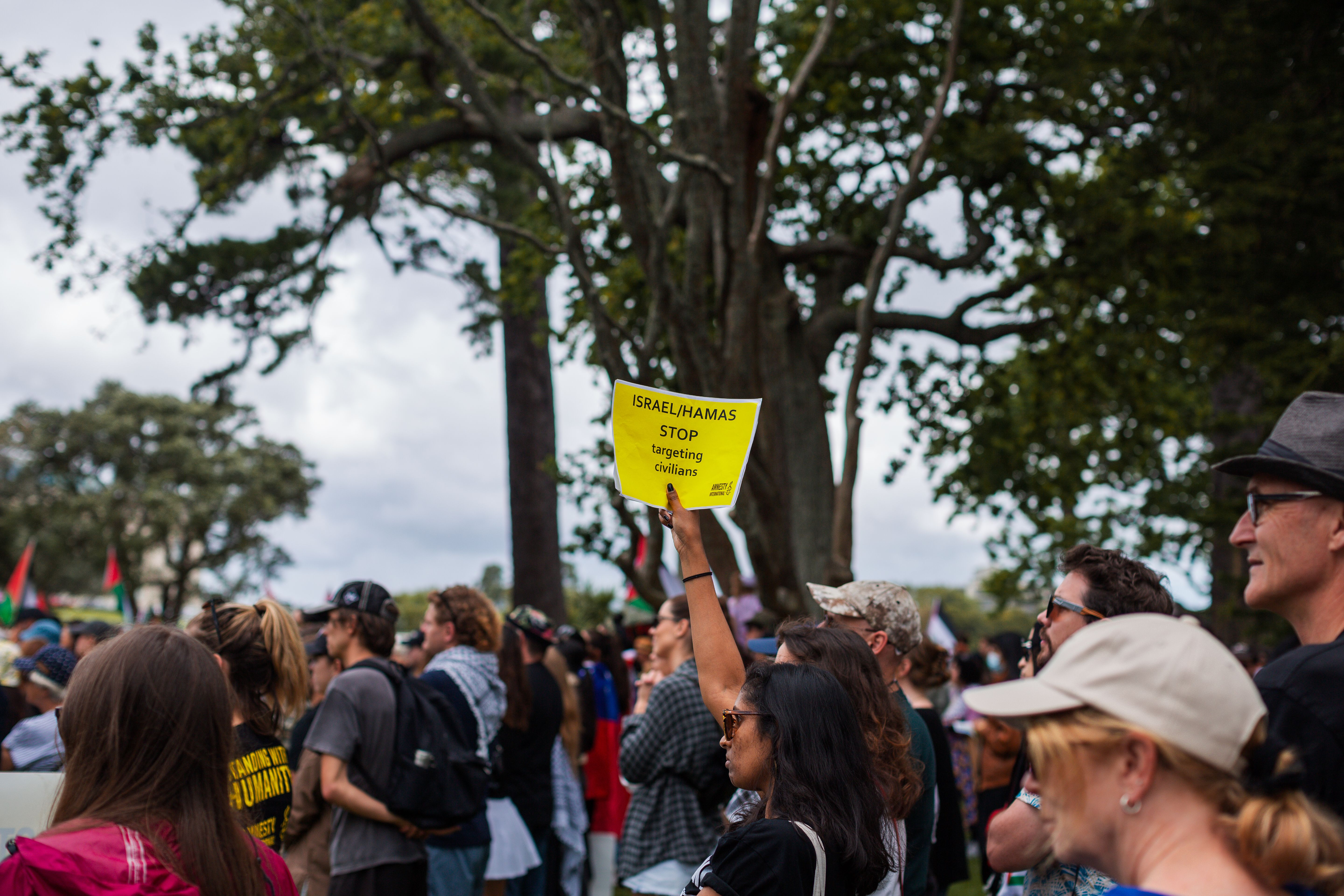 A person holds a sign calling for the protection of civilians in Israel and Gaza