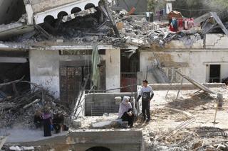 Palestinians are seen amid wreckage of residential areas after Israeli attacks during third day of the humanitarian pause in Khan Yunis
