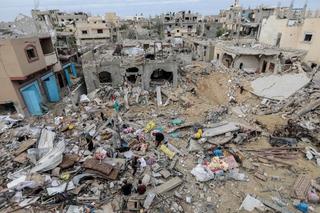 Palestinian citizens inspect the effects of destruction caused by air strikes on their homes