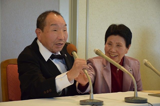 Iwao Hakamada and sister Hideko sit behind microphones.