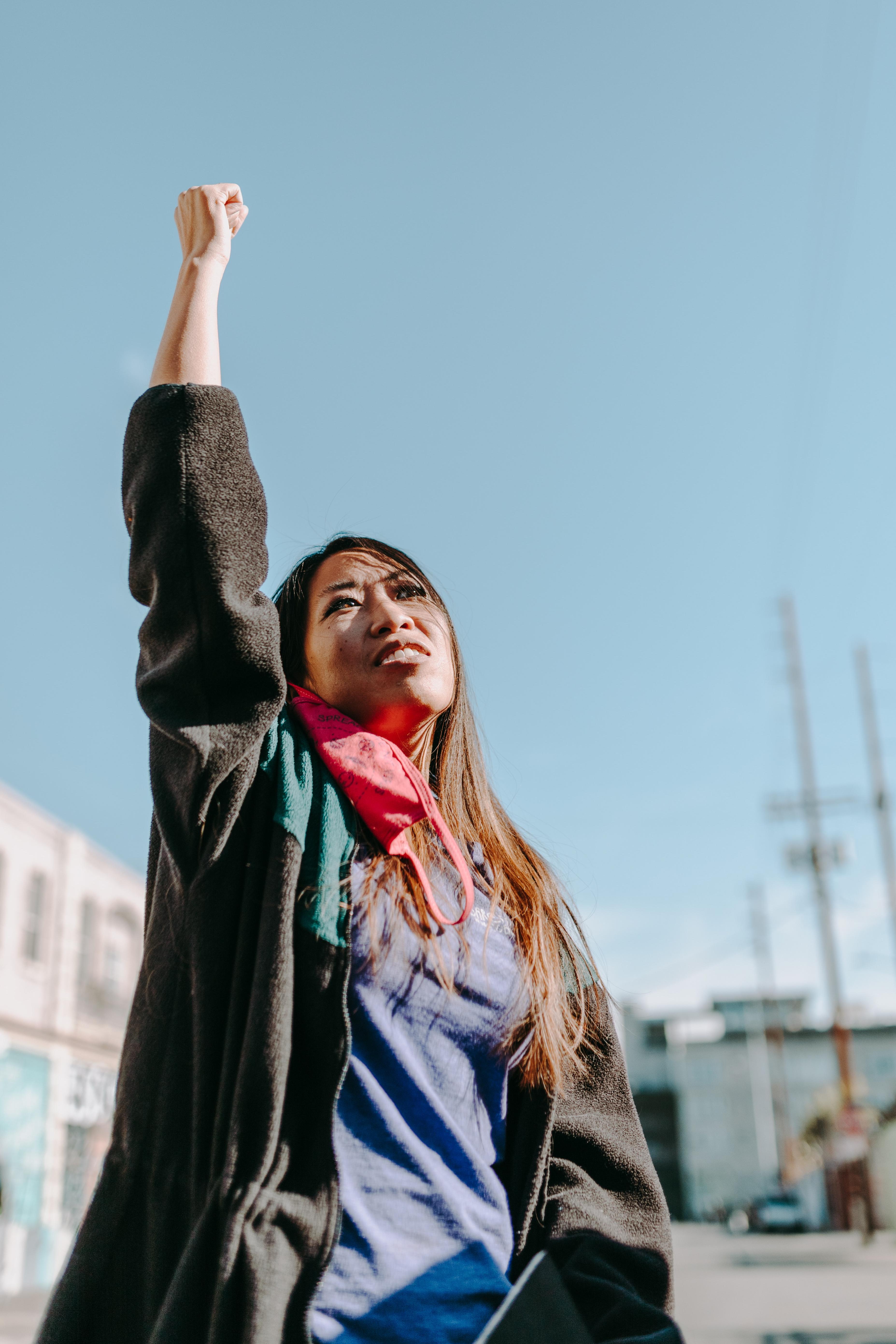 Woman stands with her fist raised