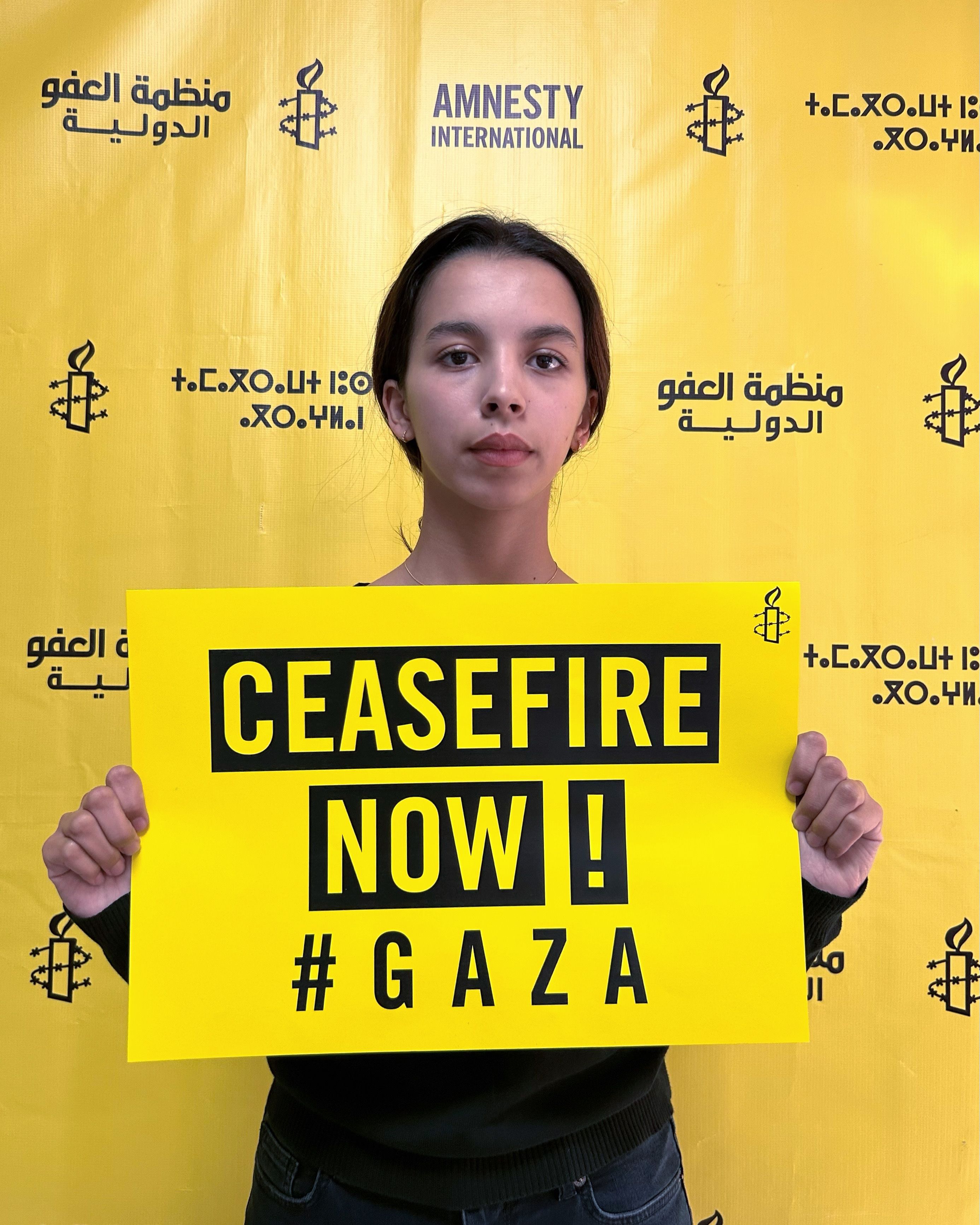 An Amnesty supporter holds a sign calling for a ceasefire in Gaza