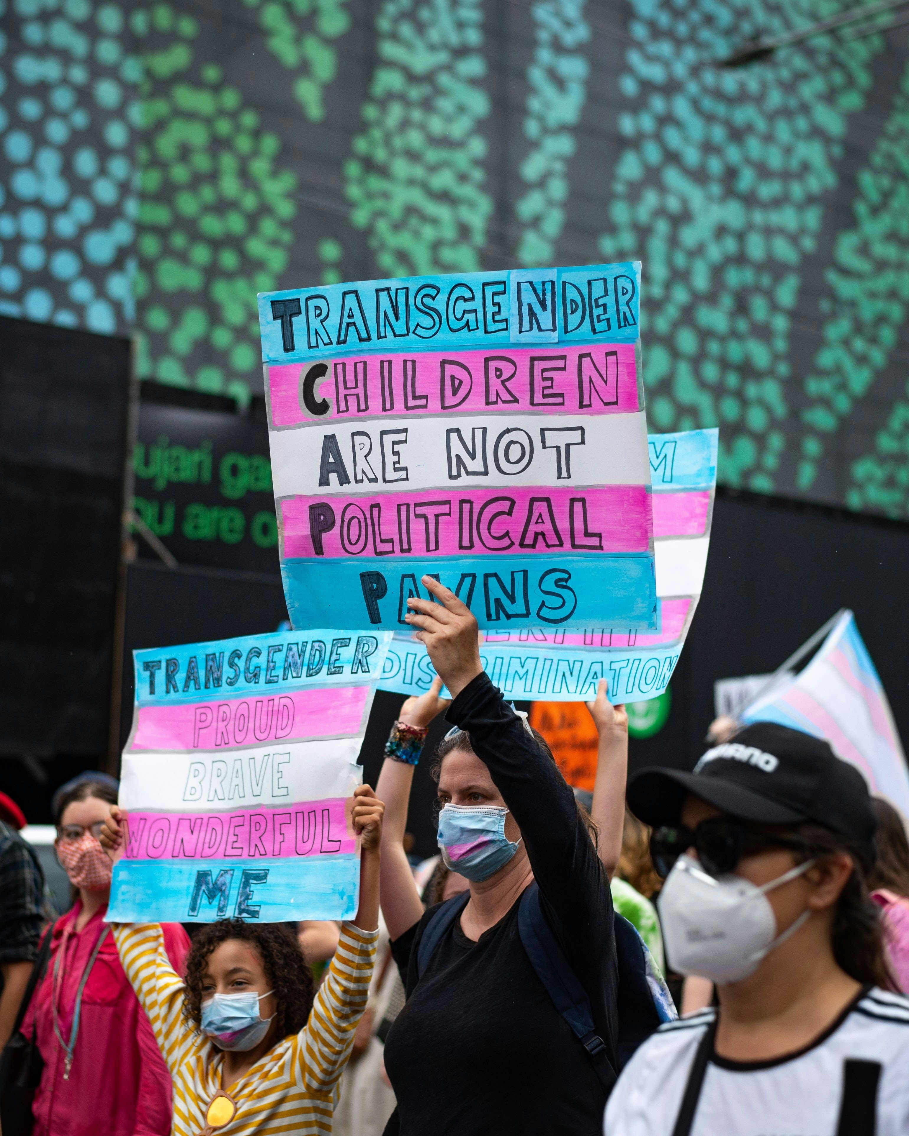 people hold pro-trans rights signs