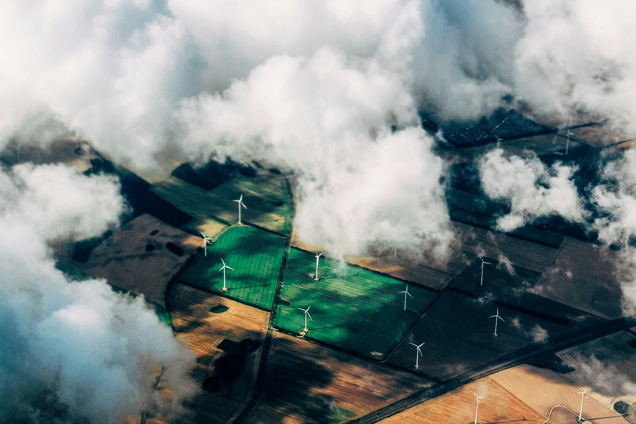 Wind farm seem from above through clouds