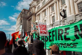 banners calling for a ceasefire in Gaza are held at a protest in Auckland