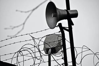 A speaker on a prison fence