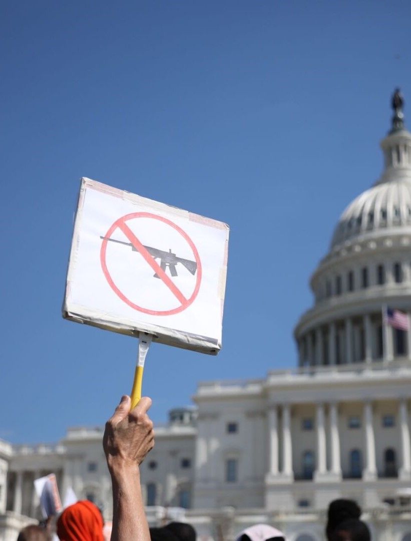 A person holds a sign calling for gun controls