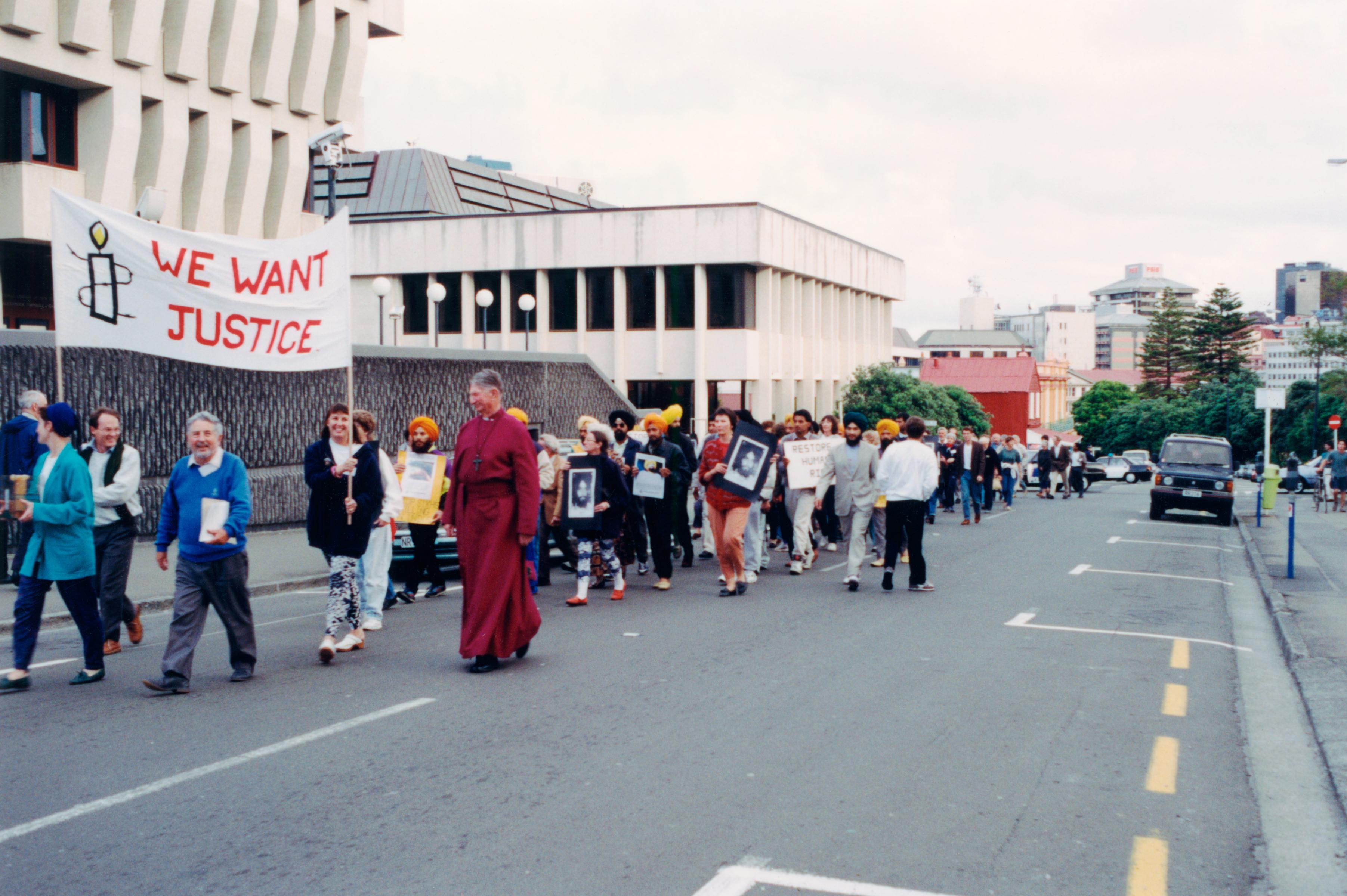 a group of people march down a street protesting in Wellington 