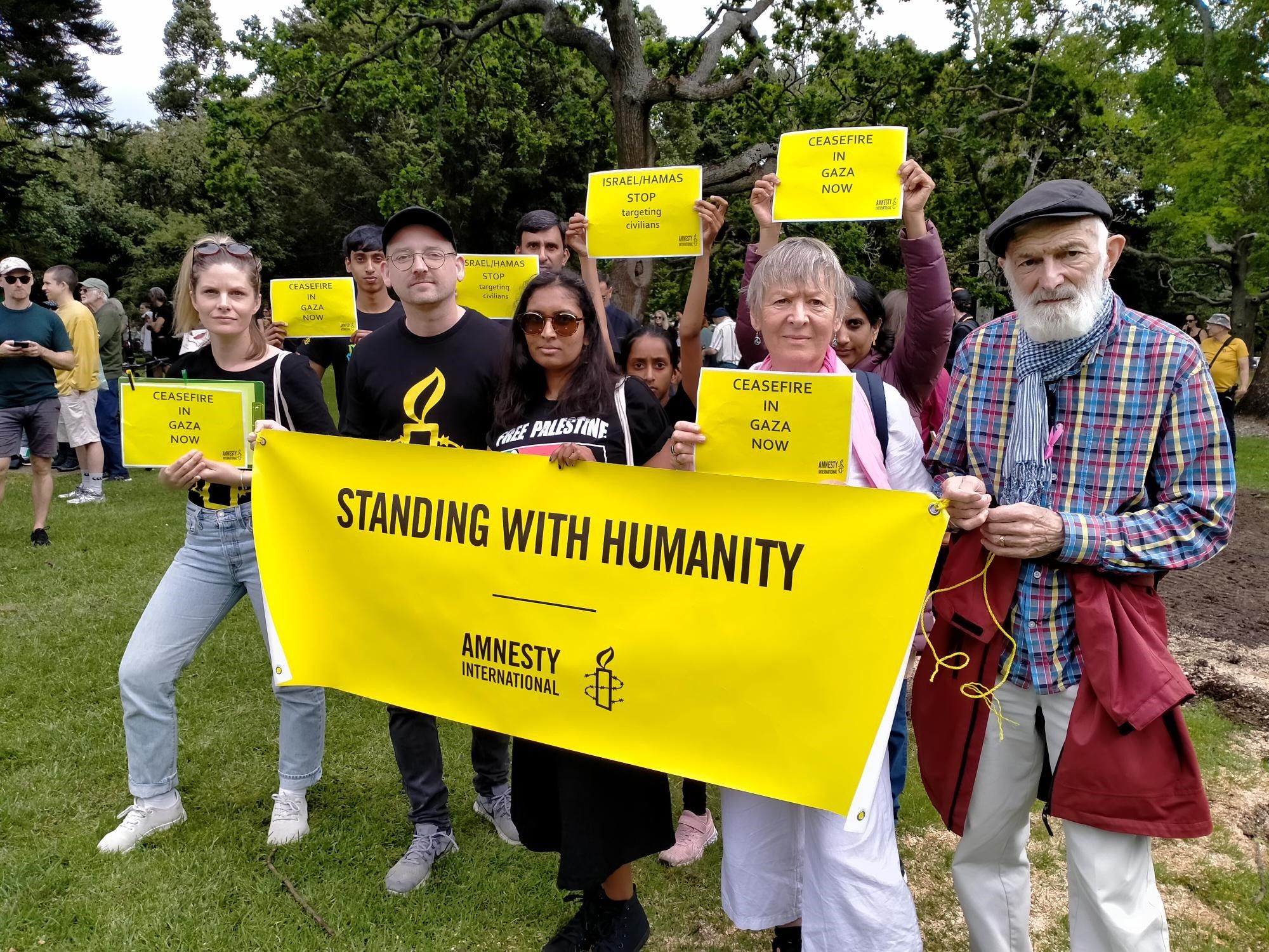 A group of people holding signs calling for a ceasefire