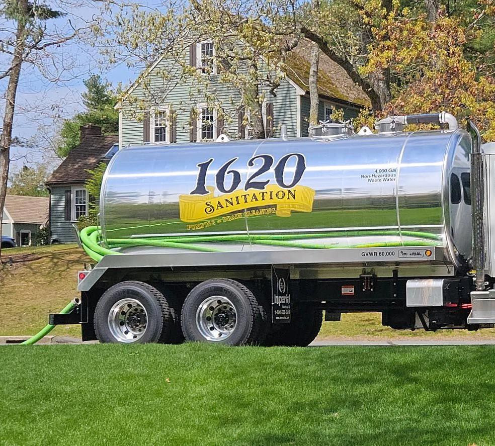 1620 Sanitation Septic Truck in Plymouth, MA 1620 Sanitation stainless steel septic pumping truck parked in front of a home