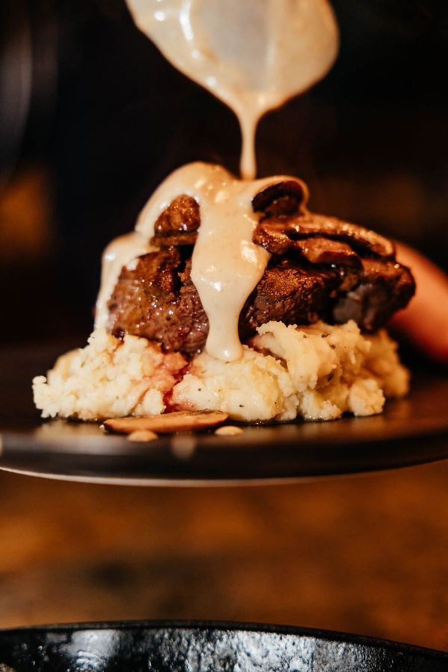 Cream sauce poured over steak and whipped potatoes