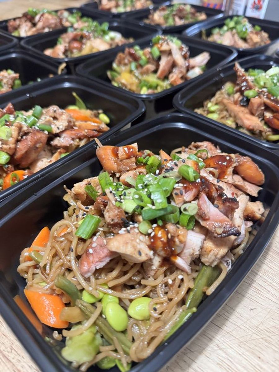 Meal prep boxes packed with chicken, rice, and vegetables