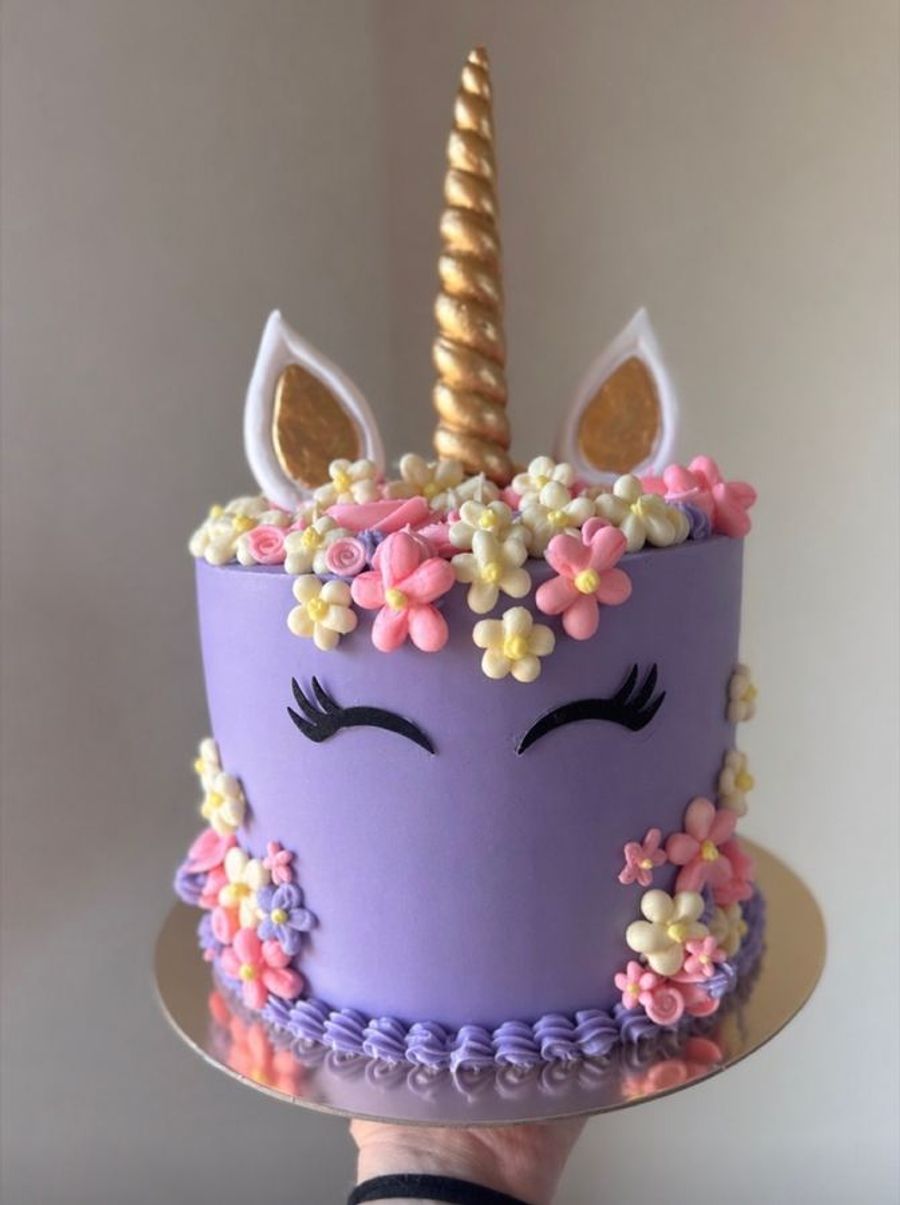 Unicorn birthday cake with a gold horn and flowers