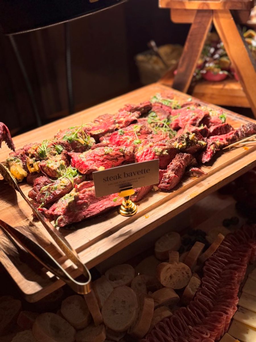 Sliced steak bavette on a carving board with herb butter