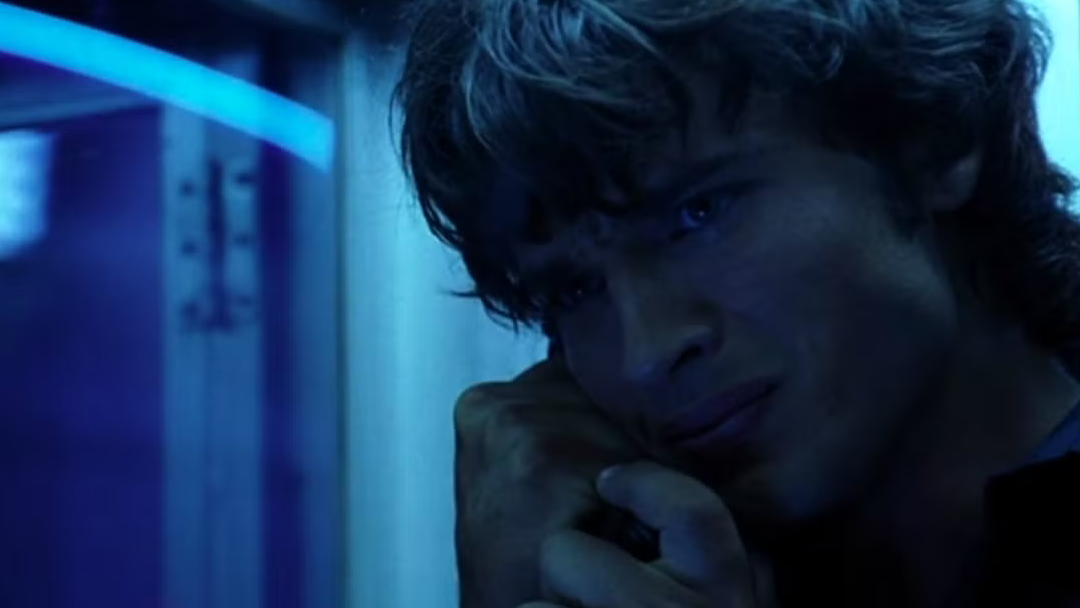 A young man looks conflicted about a phone call.