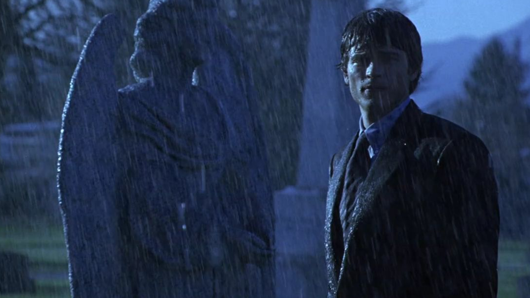 Clark standing in the rain at a cemetery. 