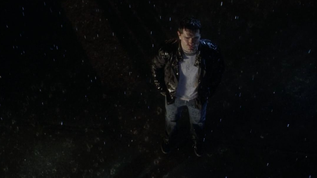 A man standing alone in the rain.