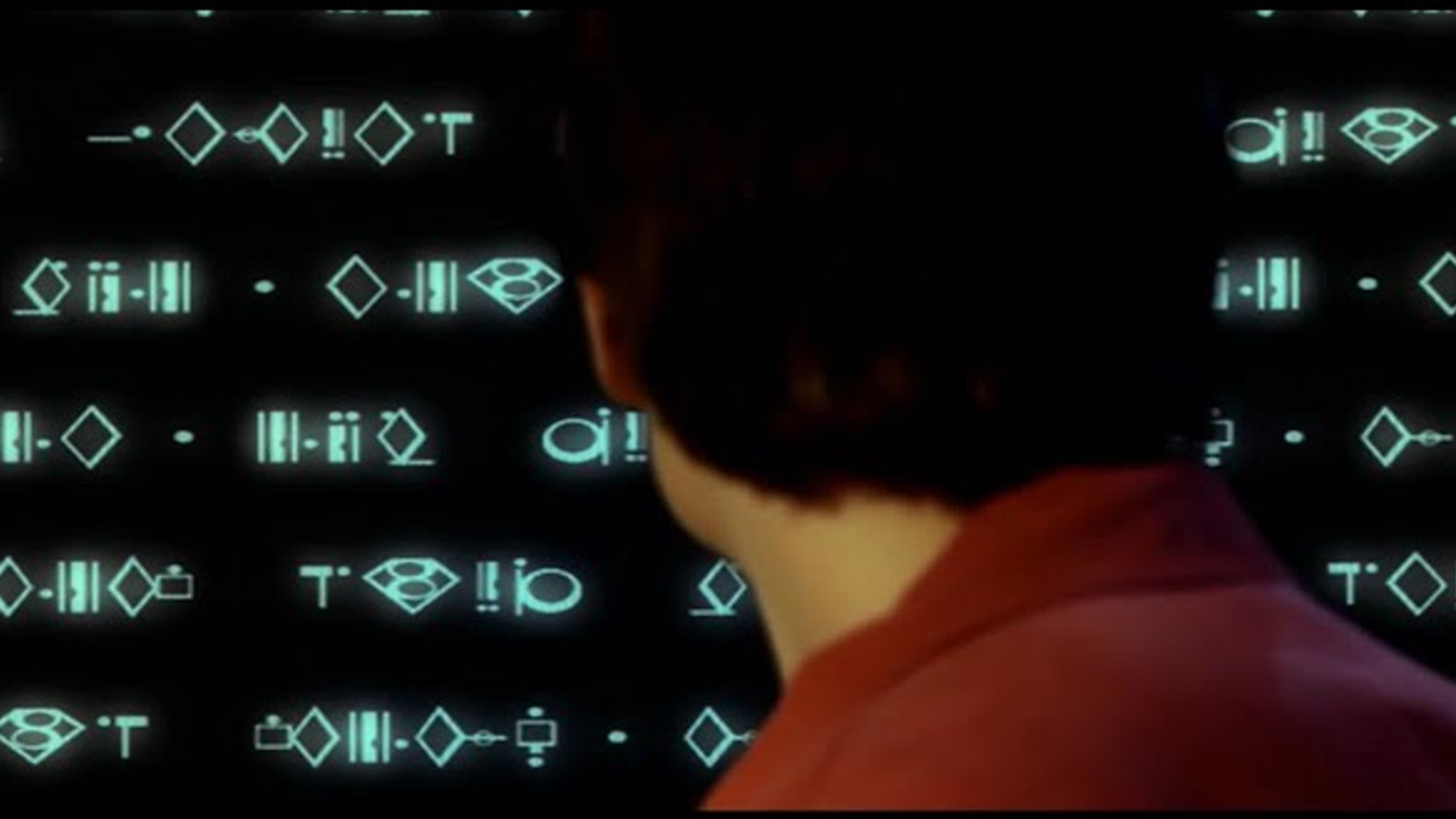 Clark Kent looking at a computer monitor.