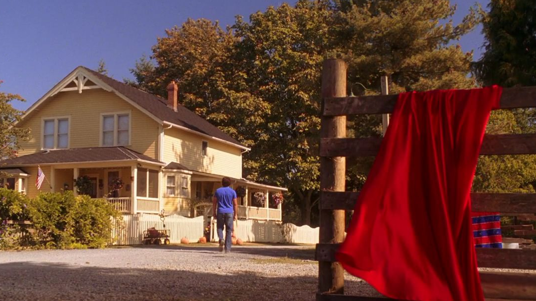 A red cape resting on a fence.