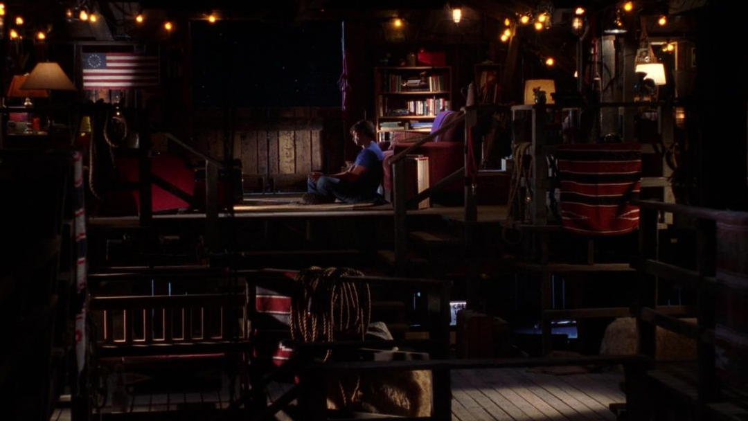 A man sitting alone in a barn loft.