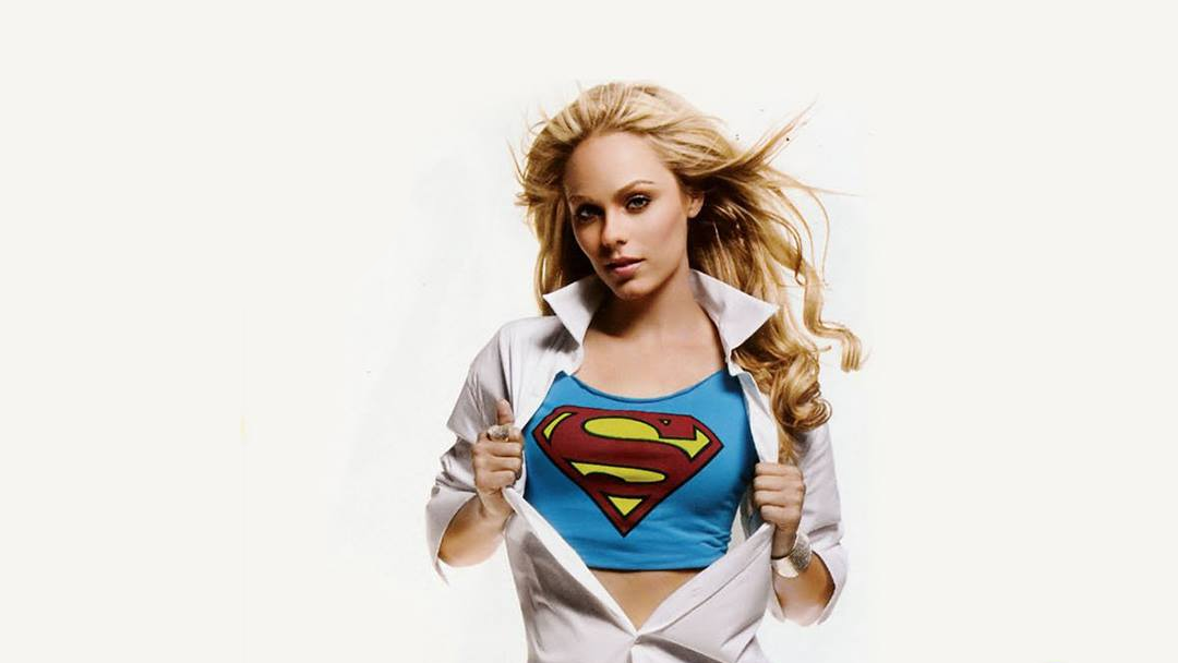 A blonde woman doing a Superman shirt rip.