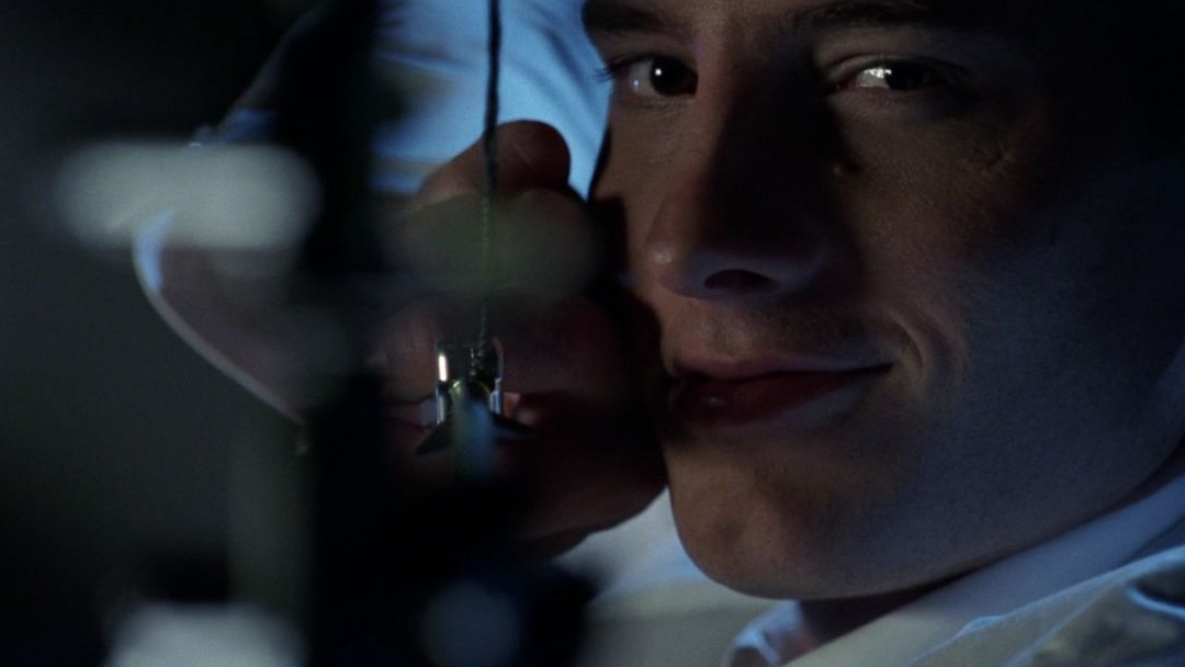 A man in a white suit nocks an arrow.