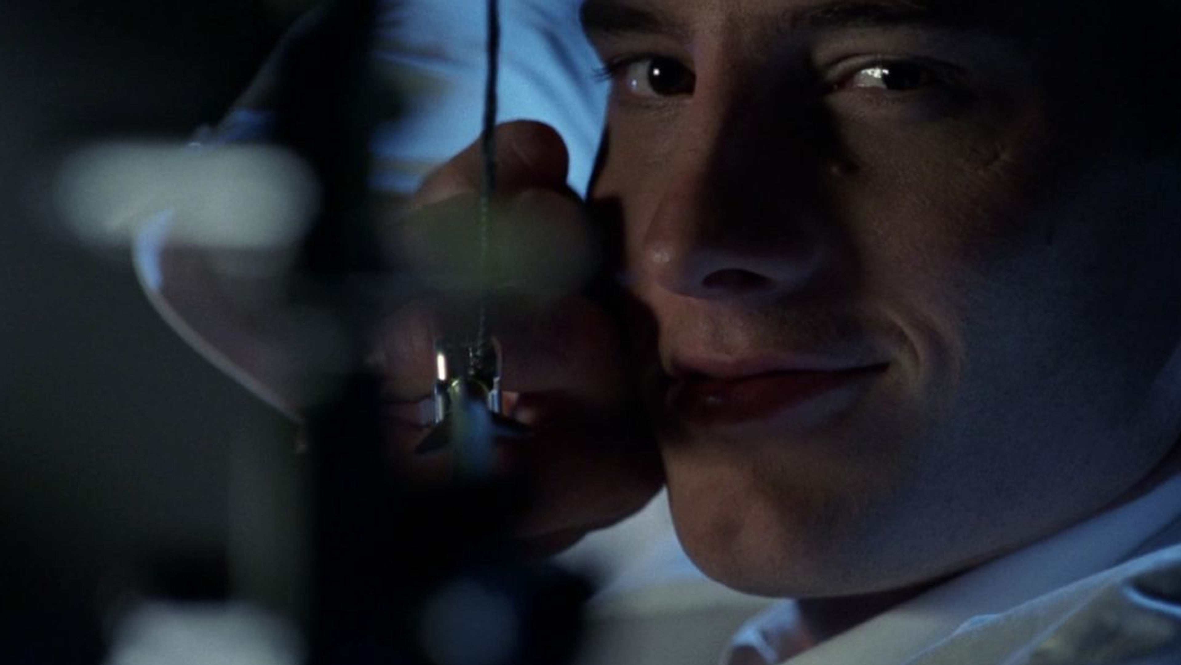 A man in a white suit nocks an arrow.