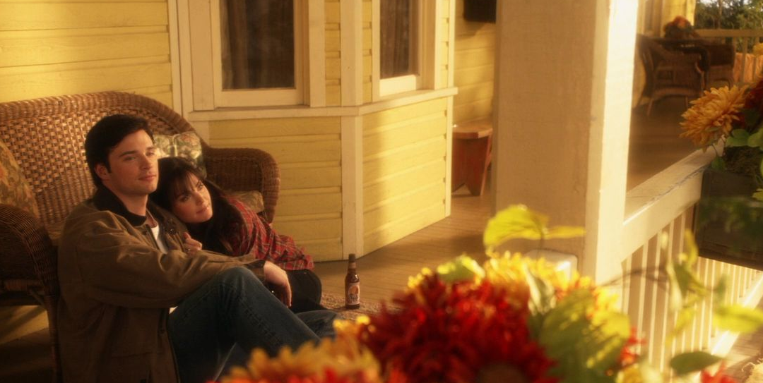 Clark and Lois sitting on the porch of the Kent farmhouse.