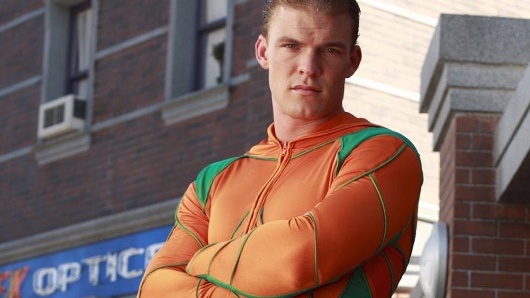 A man in an orange and green wetsuit.