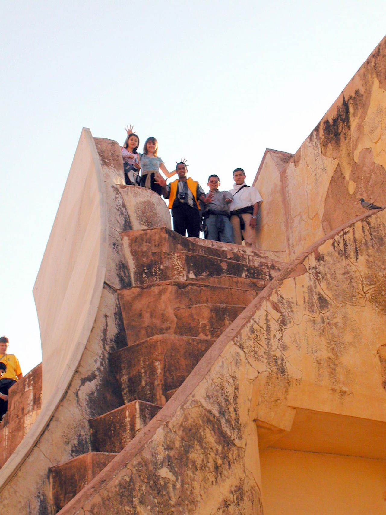Compañeros suben una escalera entre altos muros.