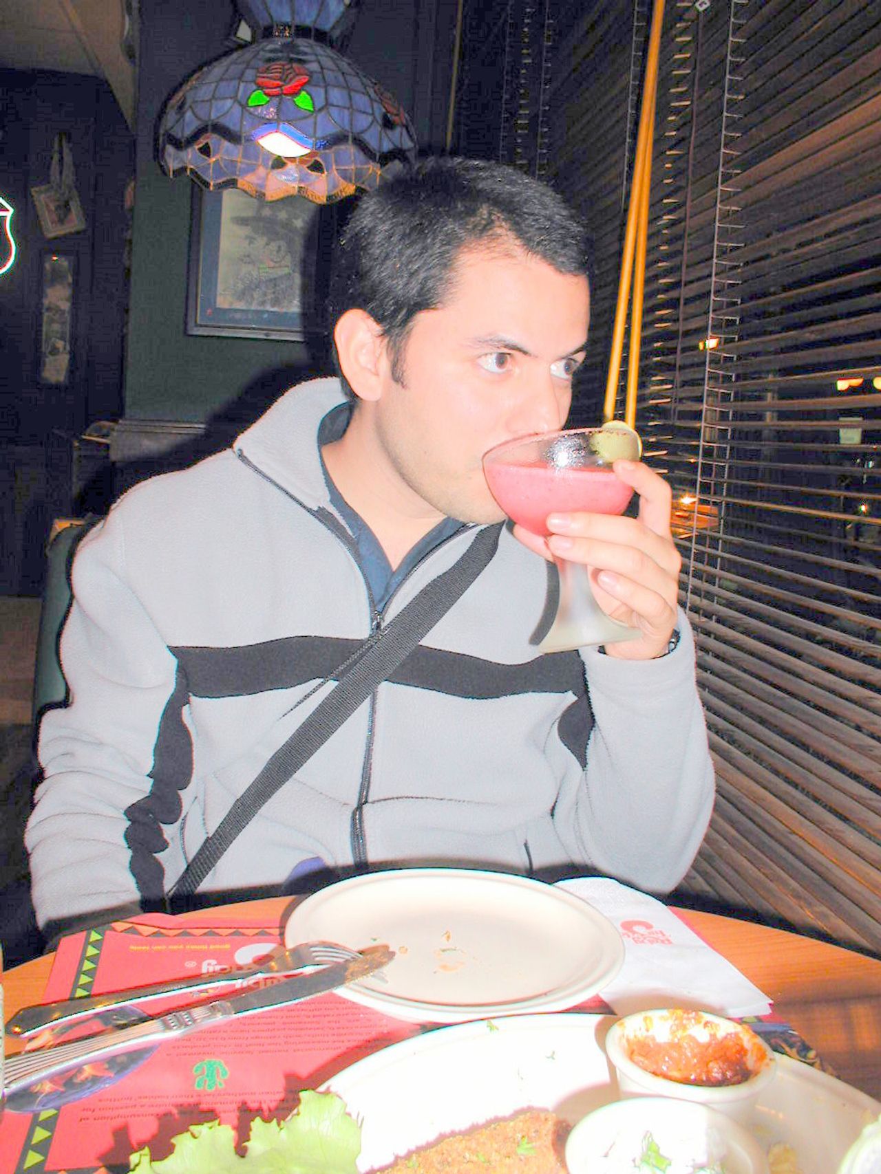 Un viajero toma una bebida en la mesa de un restaurante.