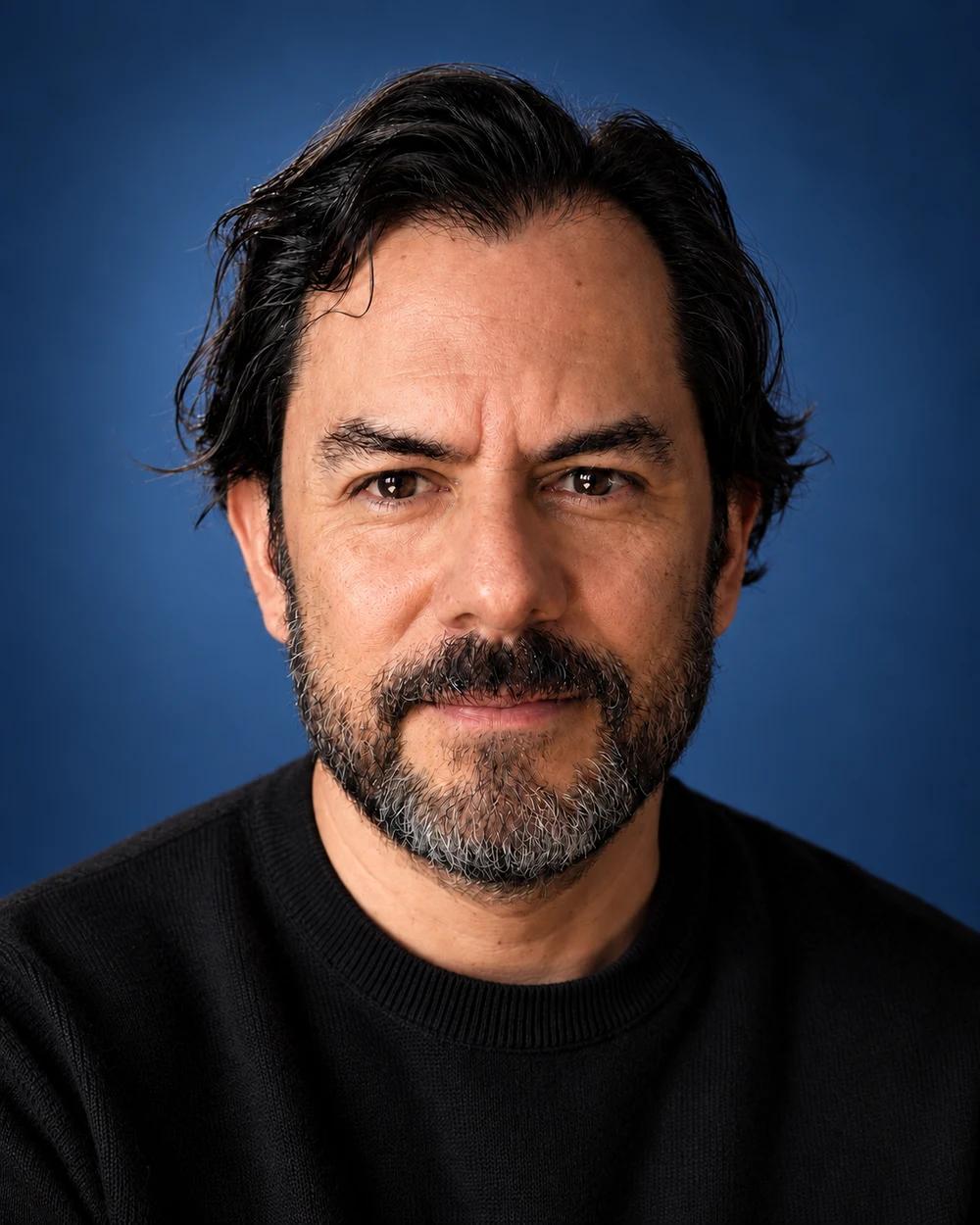 Víctor Yoalli, retrato sobre fondo azul