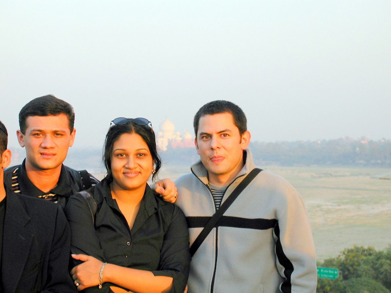 Tres compañeros posan con un paisaje al fondo.