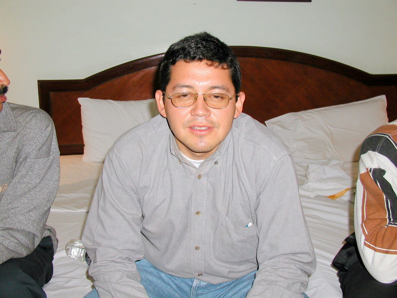 Un compañero sentado en la cama de una habitación.