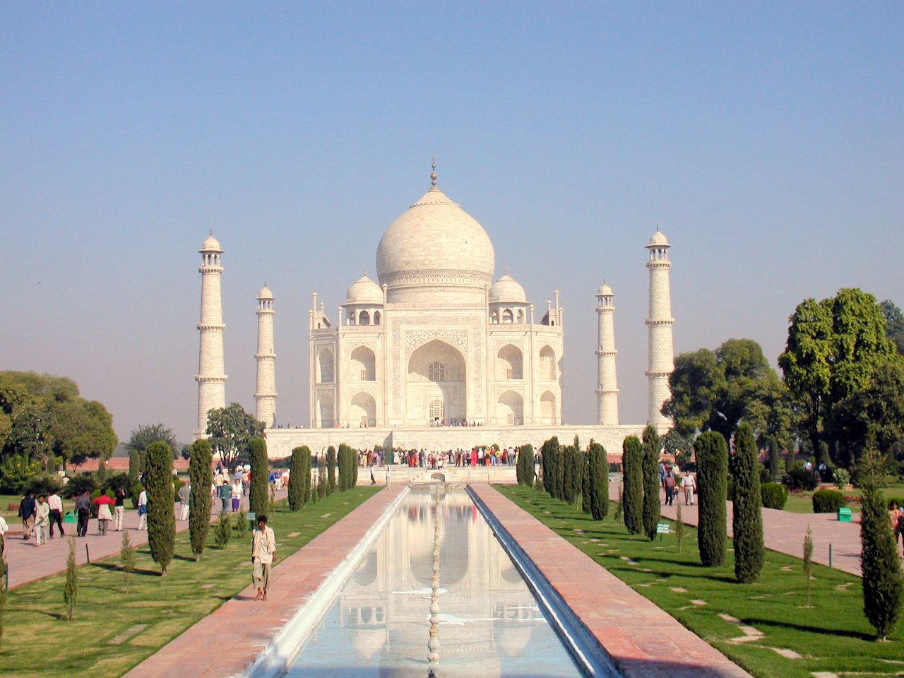 El Taj Mahal al fondo de un estanque rodeado de jardines.