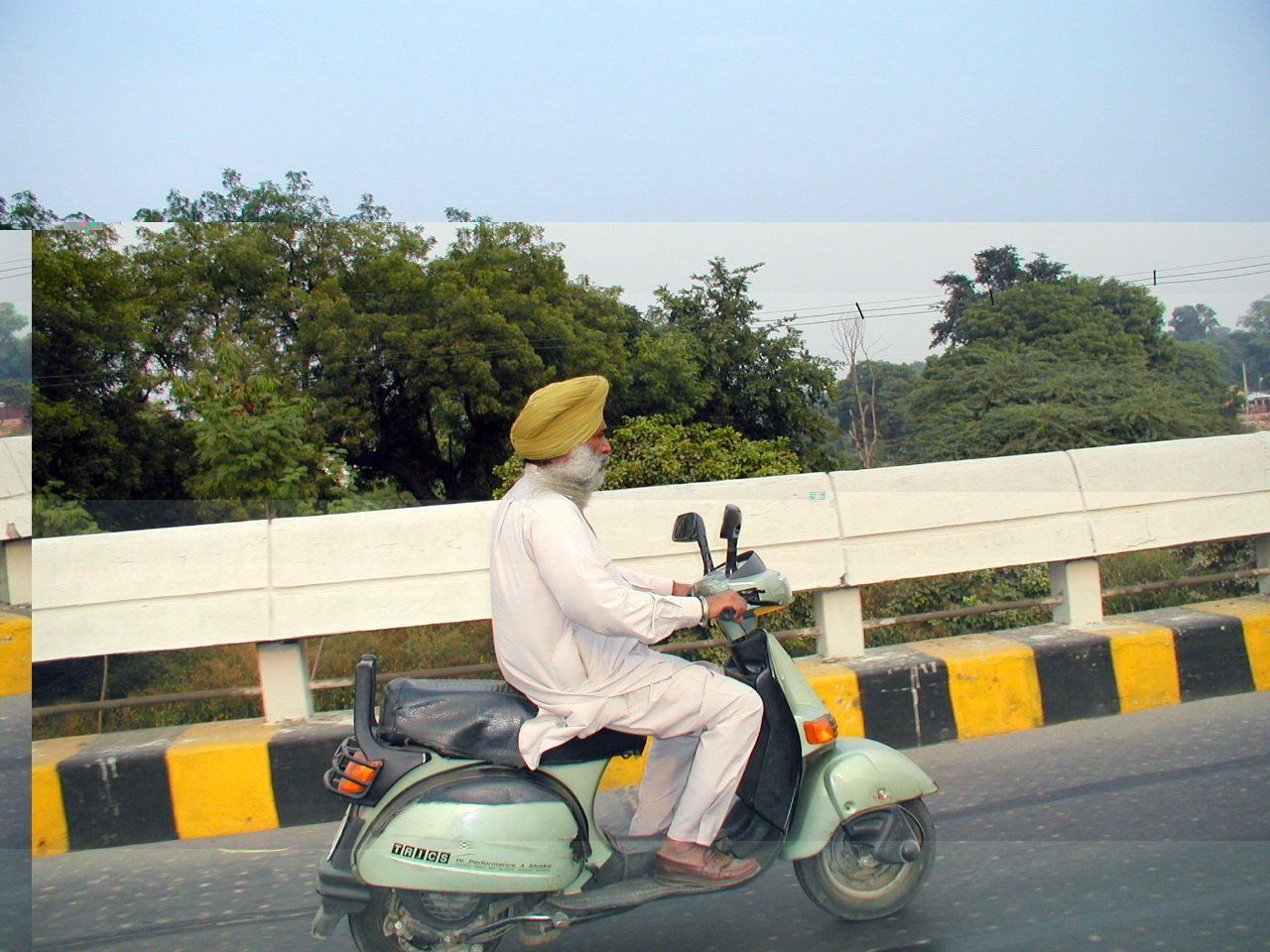 Dos personas viajan en una motocicleta por la ciudad.